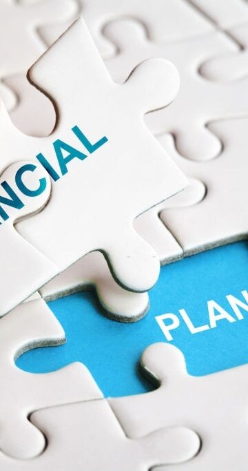 Hand holding piece of puzzle with words Financial Planning. Business concept