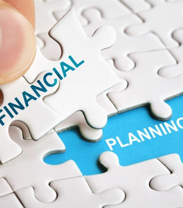 Hand holding piece of puzzle with words Financial Planning. Business concept
